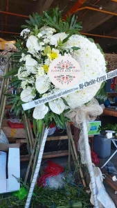 Elegant white standing sympathy arrangement by Flower Bar Cebu featuring premium blooms and lush greens.