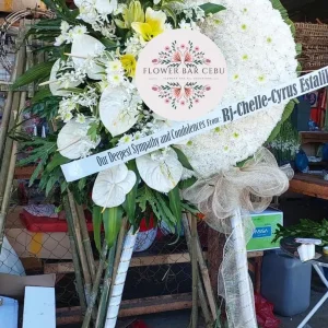 Elegant white standing sympathy arrangement by Flower Bar Cebu featuring premium blooms and lush greens.