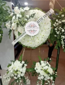 A Classic White Funeral Wreath with Coordinating Base Sprays by Flower Bar Cebu